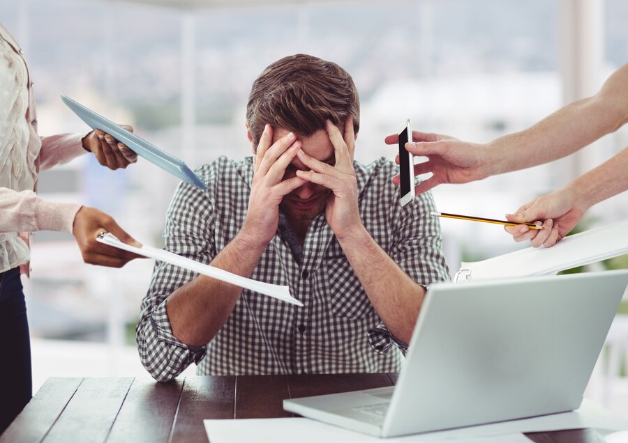 Young father in his profession stressed while at work being handed documents.