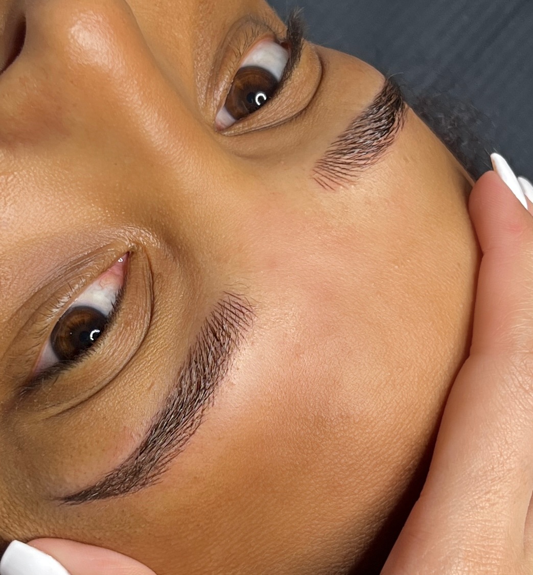 Microblading procedure: Artist creating natural hair-like strokes on client's eyebrows