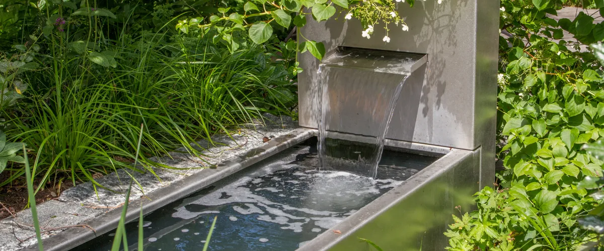 Contemporary stainless steel water feature in garden Contemporary stainless steel water feature in garden
