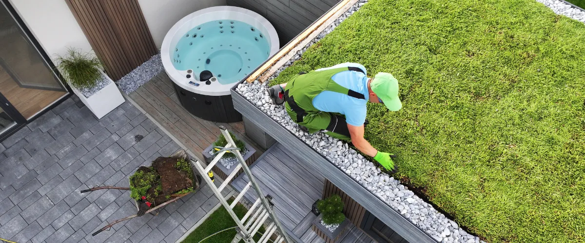 Worker installing green roof system on residential building Worker installing green roof system on residential building