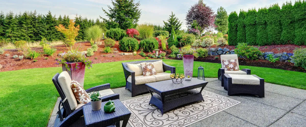 Backyard patio entertainment area with chairs and table under umbrella