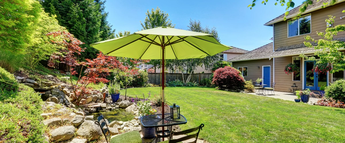 Beautiful backyard with patio, pond, and green umbrella shade