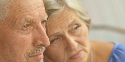 An elderly couple sits closely together, looking thoughtful. The woman rests her head against the man’s, and both have serious or contemplative expressions, symbolizing companionship, aging, or deep emotions An elderly couple sits closely together, looking thoughtful. The woman rests her head against the man’s, and both have serious or contemplative expressions, symbolizing companionship, aging, or deep emotions