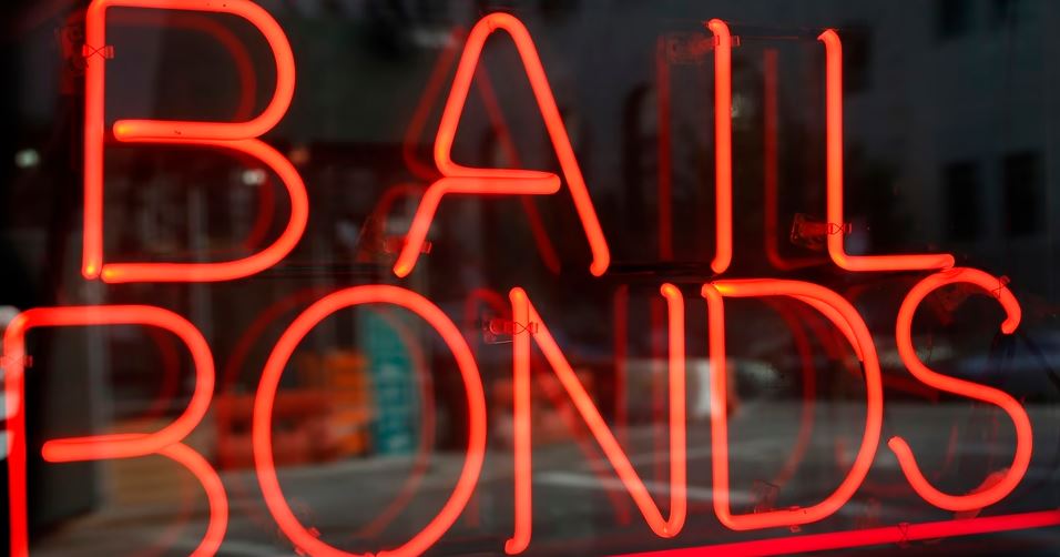 A neon sign advertising a bail bond agency storefront