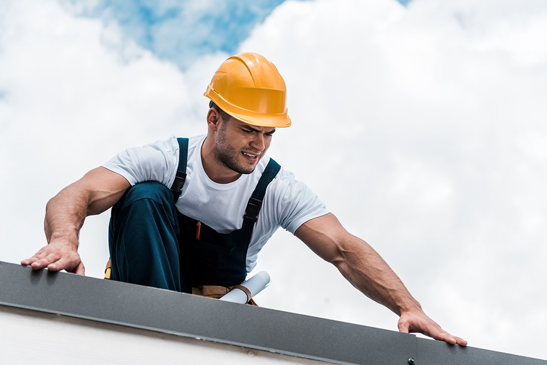 A roofer conducting a pre-storm inspection on a house. A roofer conducting a pre-storm inspection on a house.