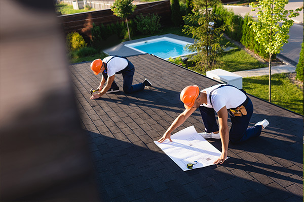 roofing contractors with blueprint and tools roofing contractors with blueprint and tools