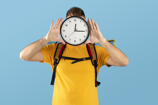 A construction worker holds a clock, embodying length of time and dedication amidst the bustling site. A construction worker holds a clock, embodying length of time and dedication amidst the bustling site.