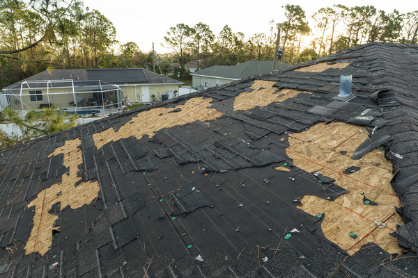 a roof battered and visible structural damage by severe weather. a roof battered and visible structural damage by severe weather.