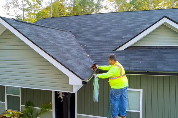 worker installs gutter for roof drainage, tools nearby worker installs gutter for roof drainage, tools nearby