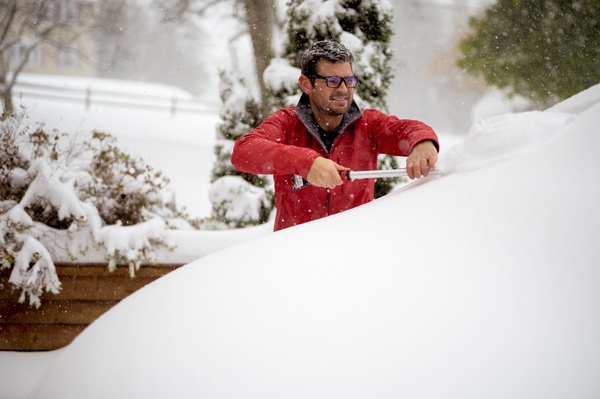 a man shovels snow off his roof, preventing potential damage and ensuring safety during winter a man shovels snow off his roof, preventing potential damage and ensuring safety during winter