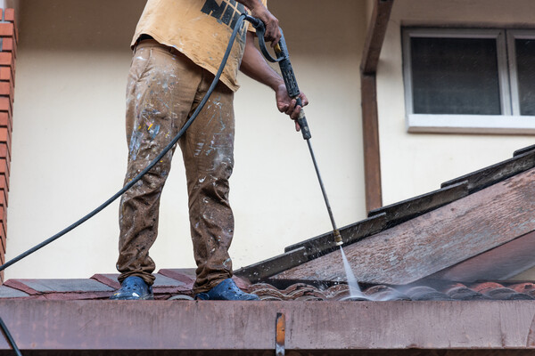 man cleans roof for winter, removing debris to prevent damage man cleans roof for winter, removing debris to prevent damage