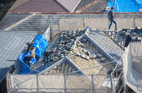 roof removal in progress as workers dismantle old materials for replacement roof removal in progress as workers dismantle old materials for replacement