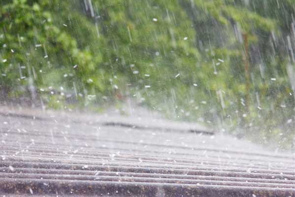 Heavy hailstorm hitting a rooftop, demonstrating the potential impact of severe weather on roof durability and maintenance. Heavy hailstorm hitting a rooftop, demonstrating the potential impact of severe weather on roof durability and maintenance.