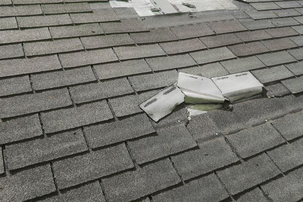 Close-up of a roof with visible shingle damage caused by hail, emphasizing the need for repairs and storm-proofing solutions. Close-up of a roof with visible shingle damage caused by hail, emphasizing the need for repairs and storm-proofing solutions.