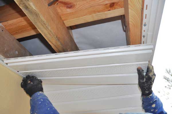Roofer installing a soffit vent, highlighting its role in enhancing roof ventilation and preventing moisture buildup. Roofer installing a soffit vent, highlighting its role in enhancing roof ventilation and preventing moisture buildup.