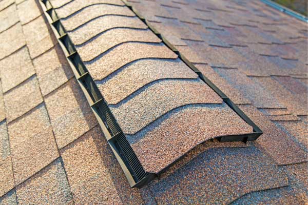 Close-up of a ridge vent installed on a shingle roof, showcasing efficient roof ventilation for improved airflow and moisture management. Close-up of a ridge vent installed on a shingle roof, showcasing efficient roof ventilation for improved airflow and moisture management.