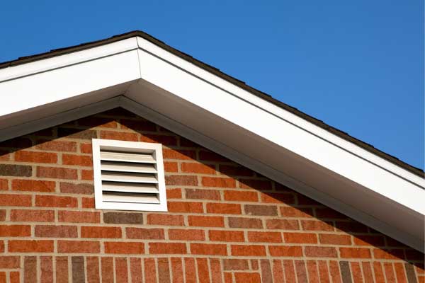 Brick house with a gable vent, emphasizing the importance of proper roof ventilation for regulating attic temperature and airflow. Brick house with a gable vent, emphasizing the importance of proper roof ventilation for regulating attic temperature and airflow.