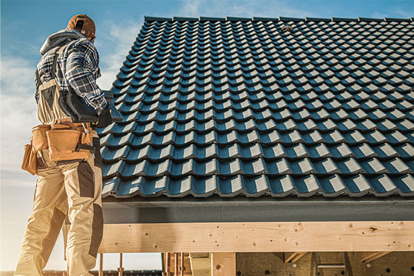 Roofer inspecting a modern tiled roof, highlighting the latest roofing trends for durability and aesthetic appeal. Roofer inspecting a modern tiled roof, highlighting the latest roofing trends for durability and aesthetic appeal.