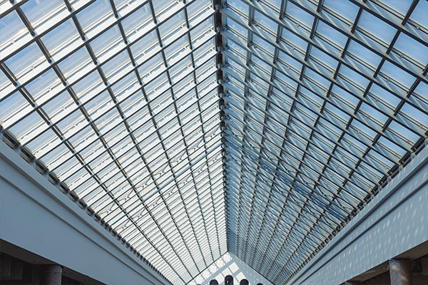 Modern glass-paneled roof structure showcasing innovative roofing design with natural light streaming through the panels. Modern glass-paneled roof structure showcasing innovative roofing design with natural light streaming through the panels.