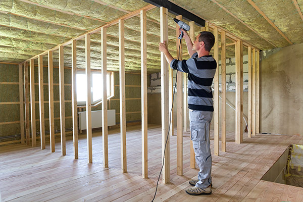 Home renovation project with a contractor installing wooden framing for a new attic space. Home renovation project with a contractor installing wooden framing for a new attic space.