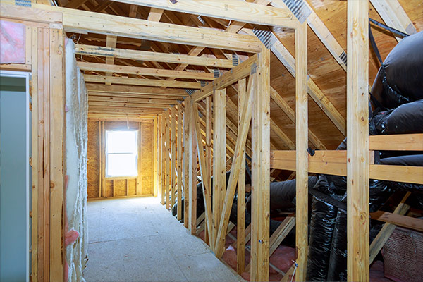 Unfinished attic with wooden beams and insulation, showcasing proper ventilation and structural integrity. Unfinished attic with wooden beams and insulation, showcasing proper ventilation and structural integrity.