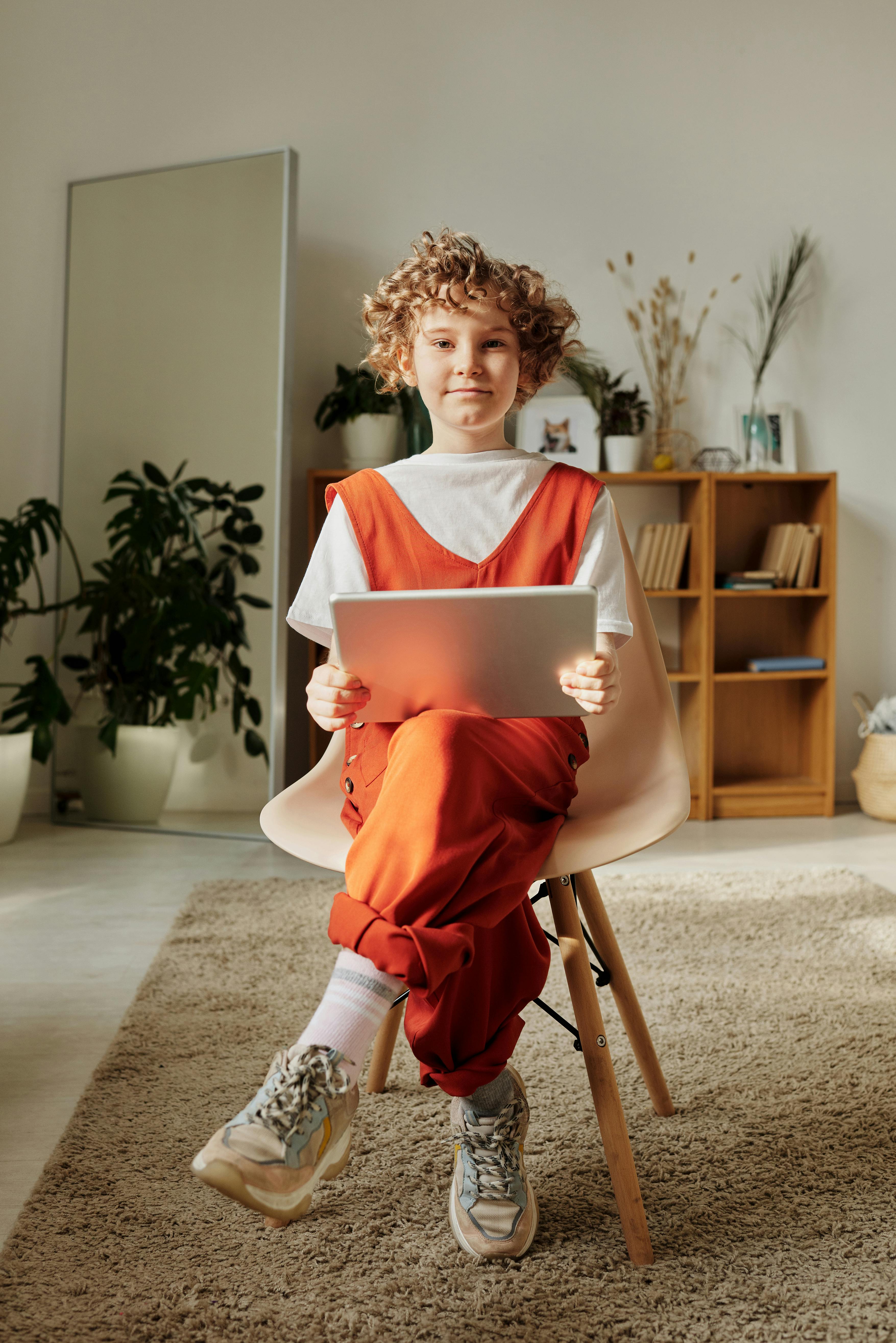 Kiddo looking at the camera with laptop on lap. 