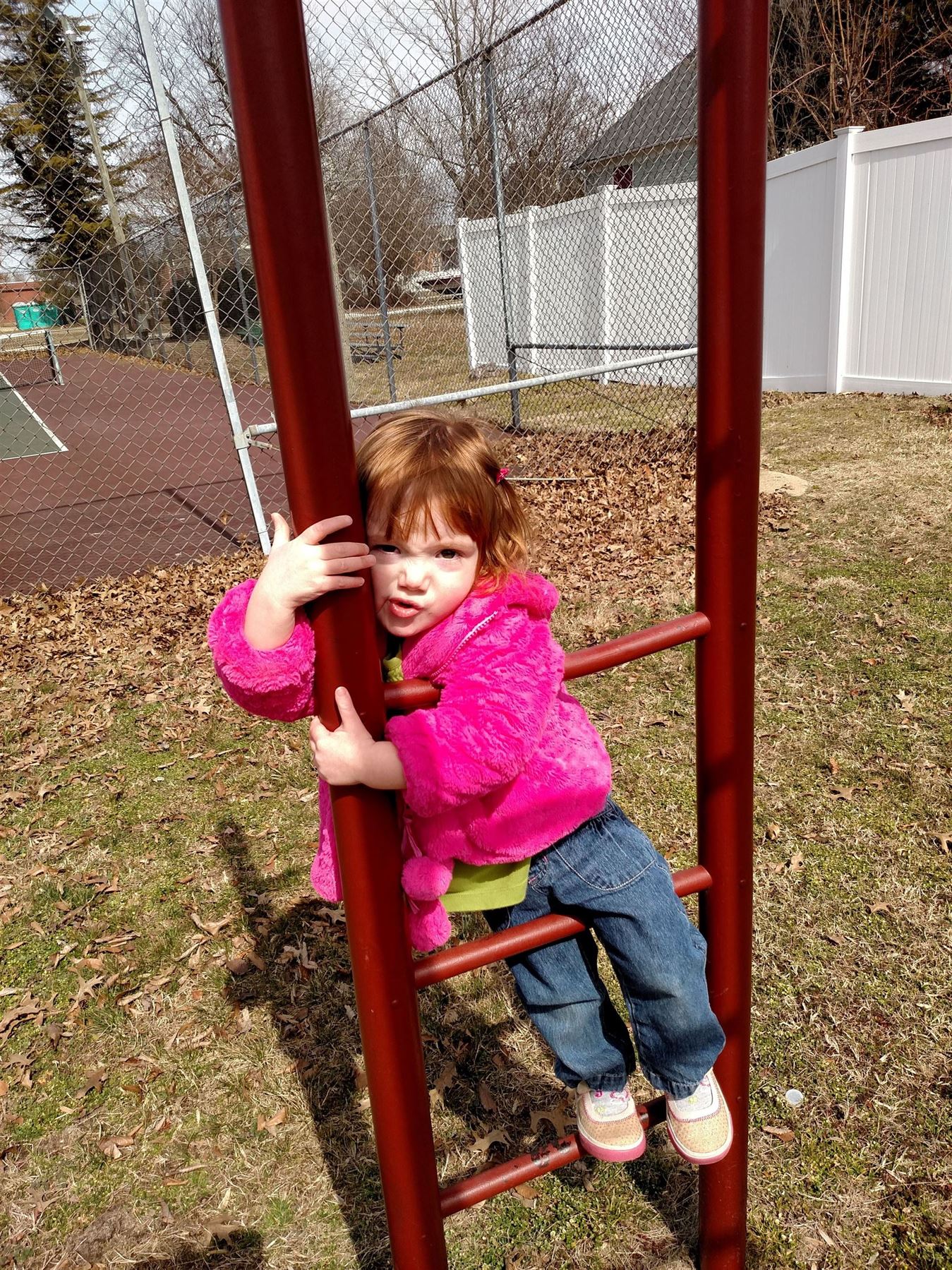 Fiona with a smooshed face on the monkey bars