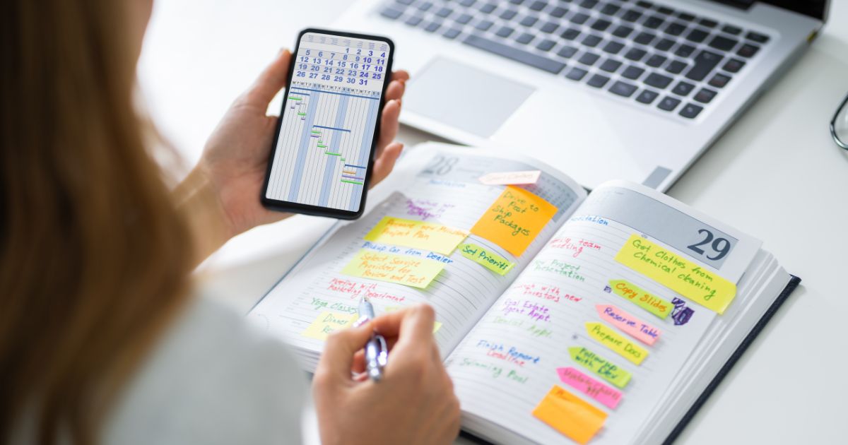 woman checking schedules in book and phone woman checking schedules in book and phone