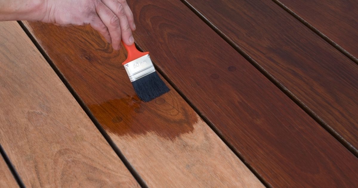 man holding brush and staining a deck man holding brush and staining a deck