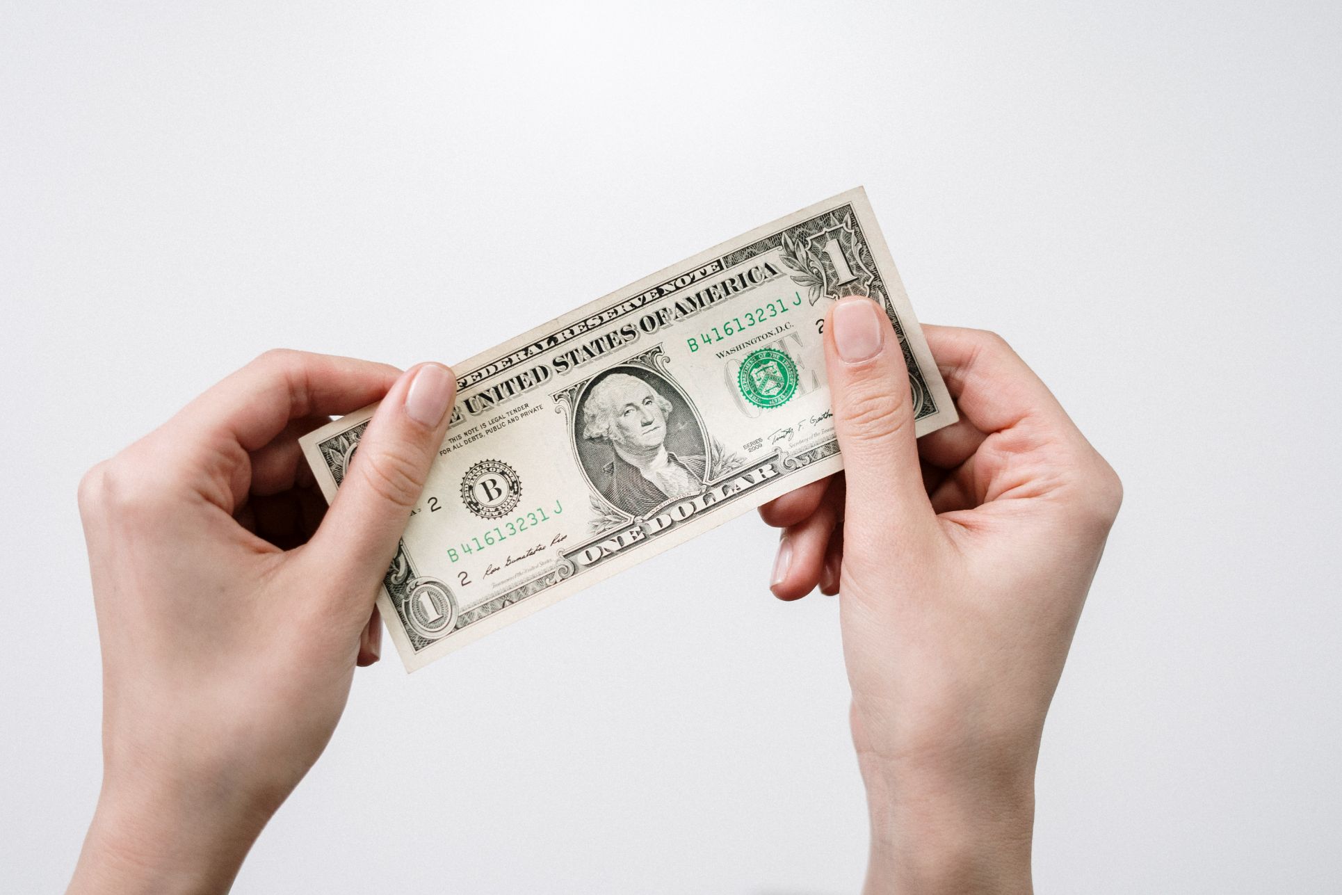 Hands holding up a dollar bill