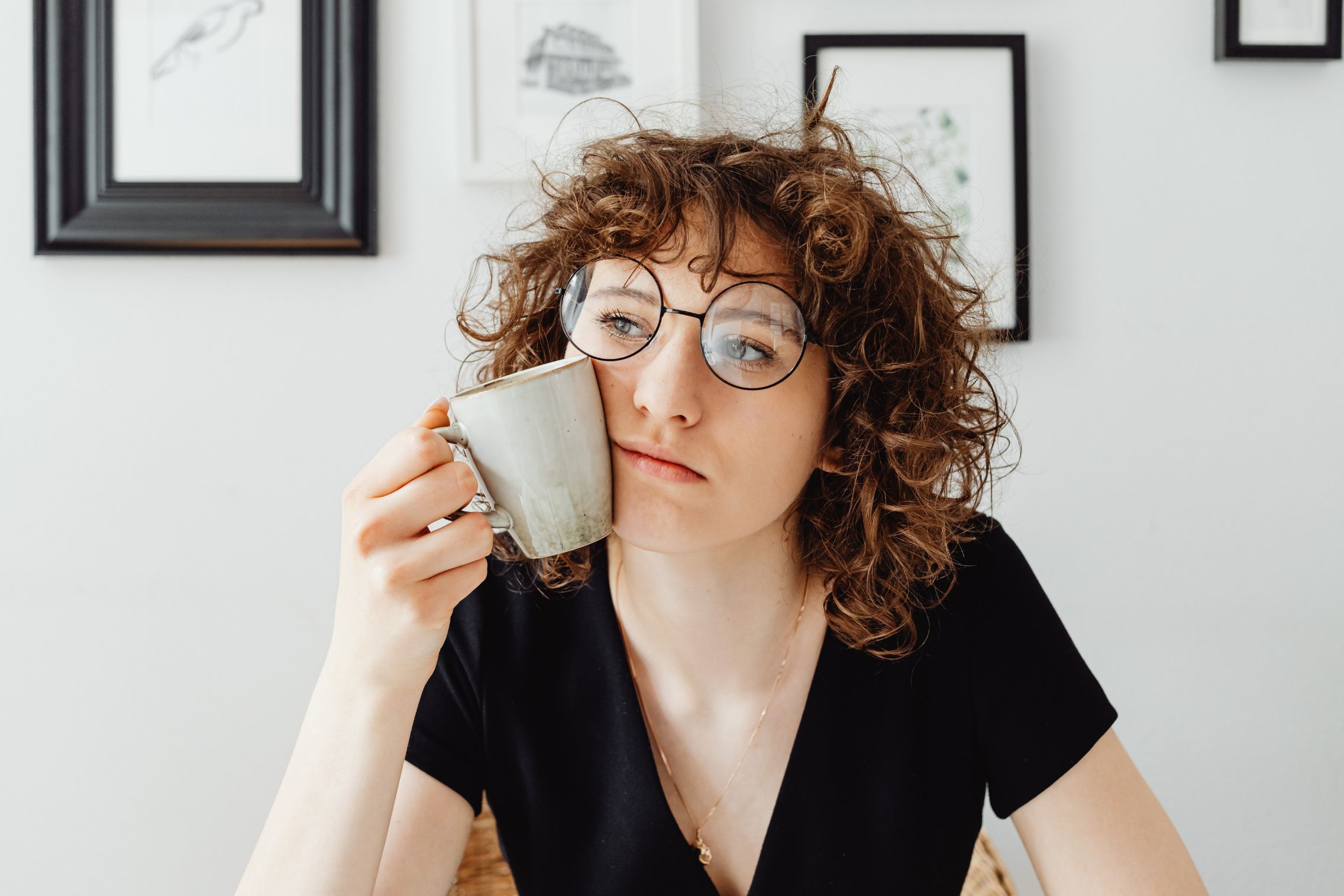 Woman holding mug to her face in consideration