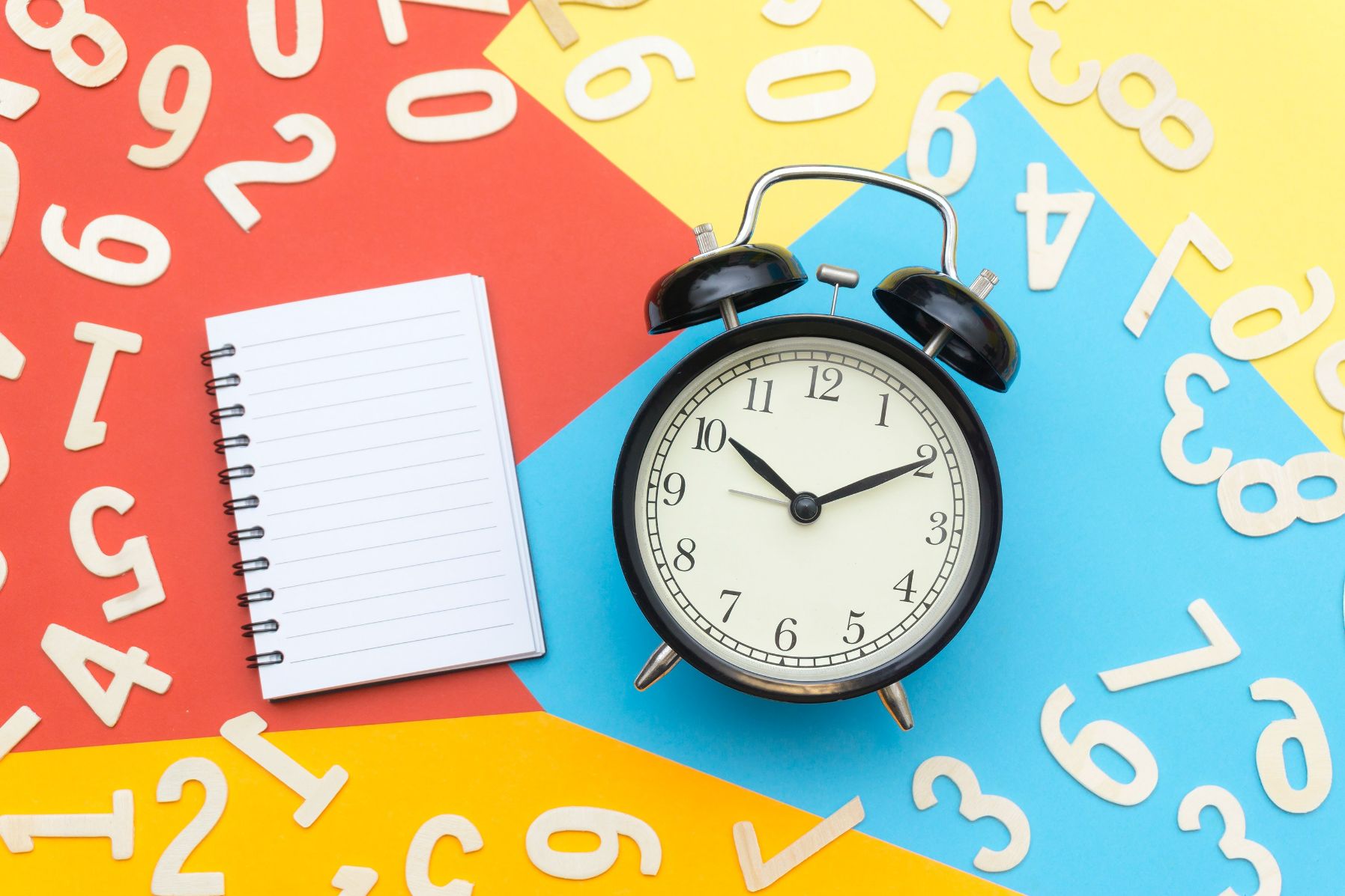 clock laying next to a notepad for someone to restart their goals