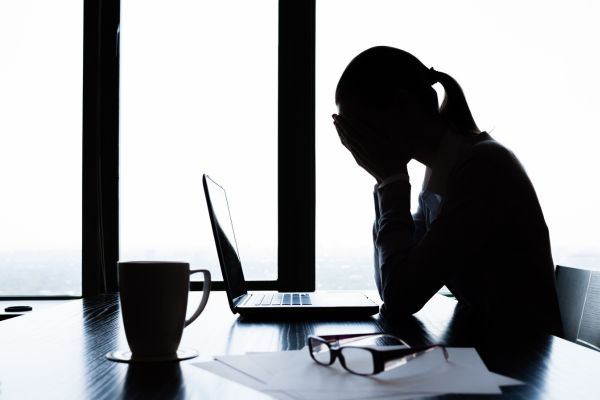 Woman stressed at work experiencing burnout as a leader