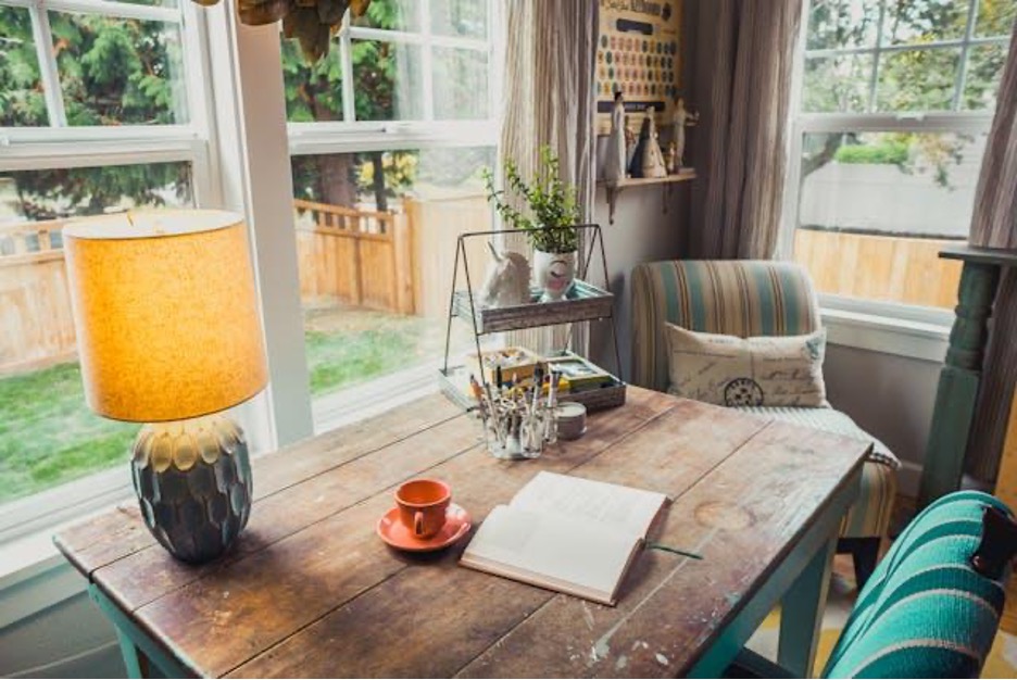 A lamp on a desk near the window pane