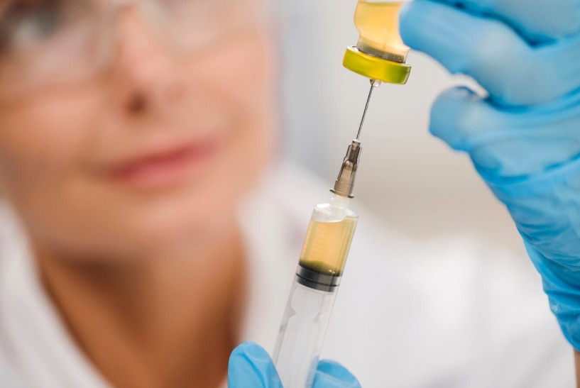 High angle of a focused female scientist using a syringe High angle of a focused female scientist using a syringe