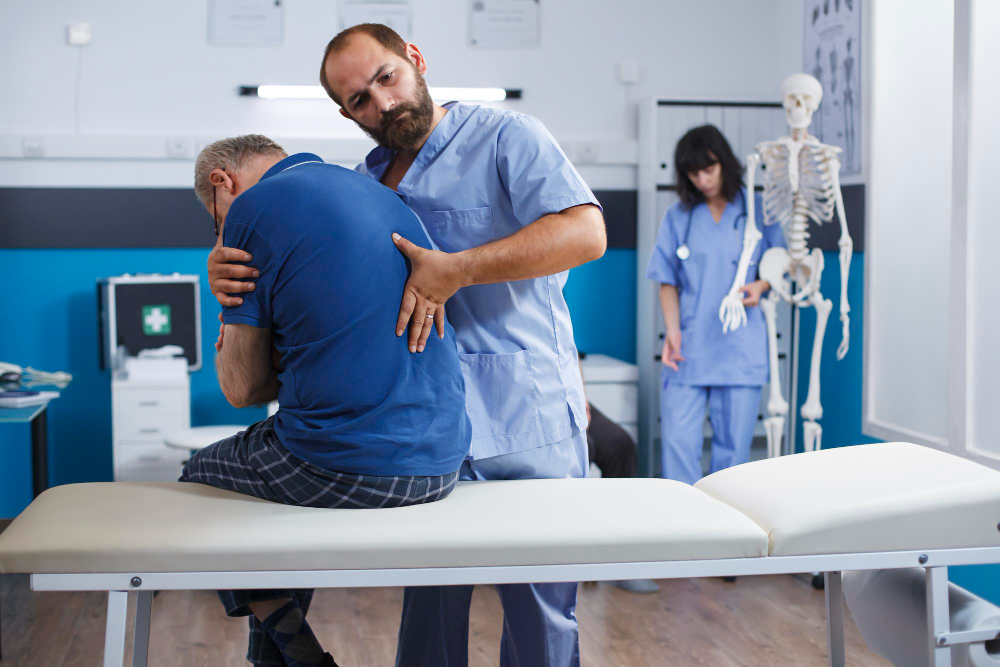 a male chiropractor helping an old patient a male chiropractor helping an old patient