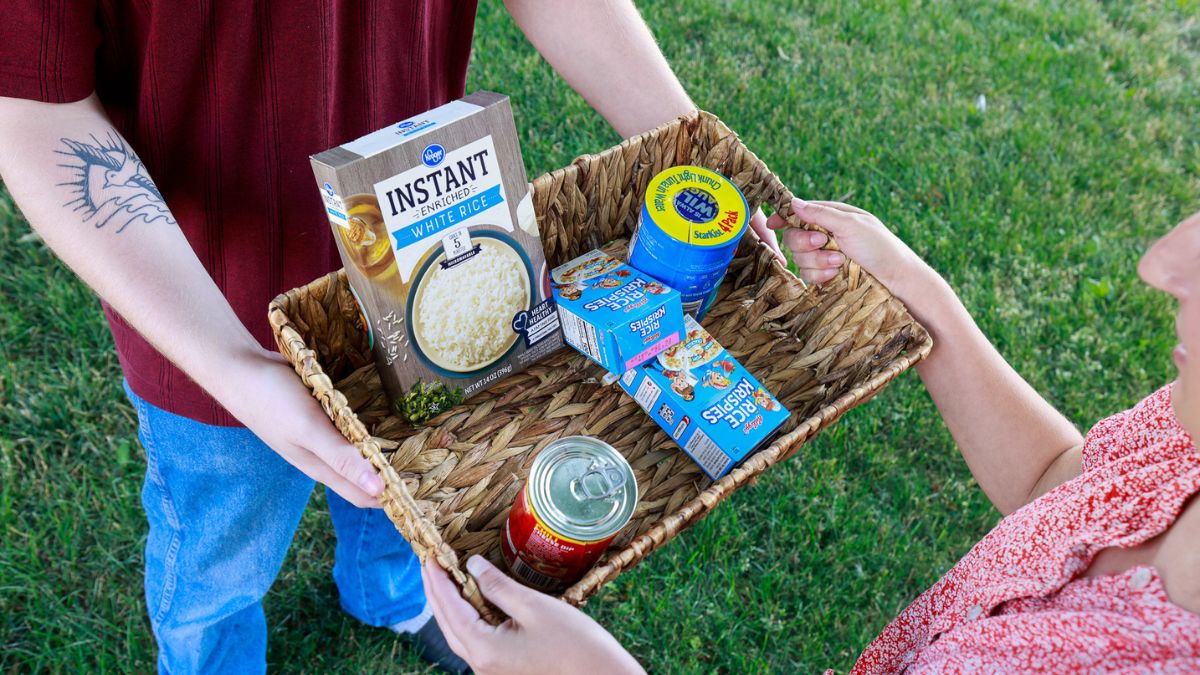 A man passing a basket of food to a woman as concept for church food donation drive.