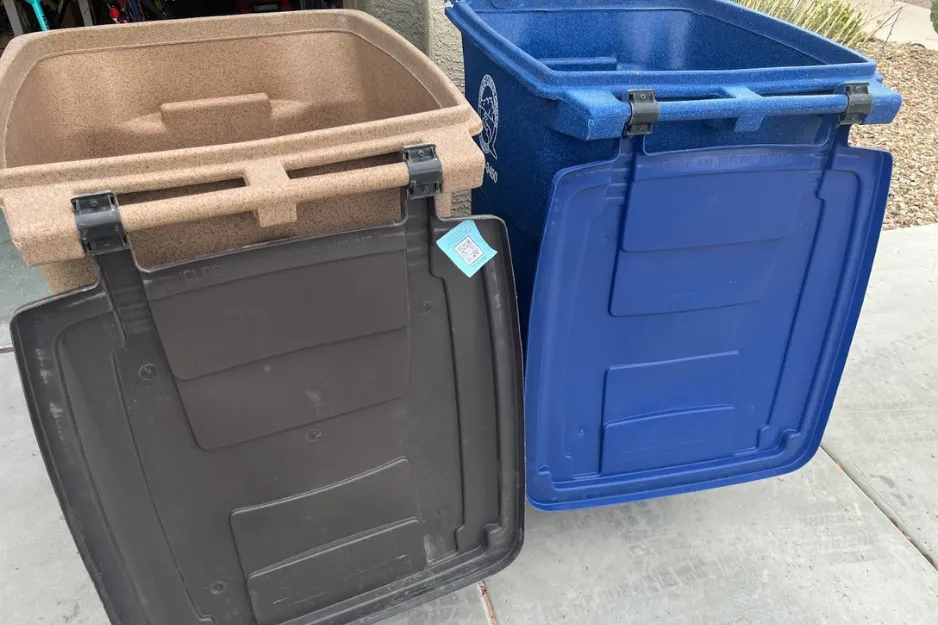 Brown and blue trash bins with open lids showing their interiors Brown and blue trash bins with open lids showing their interiors