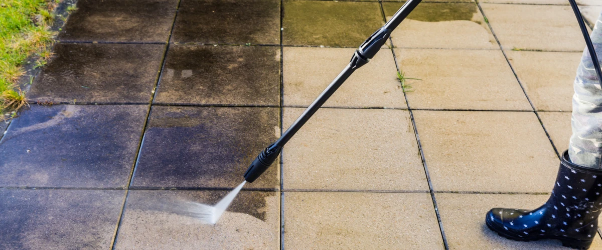 Worker using a pressure washer to clean concrete pavers in Foothills Village AZ. Worker using a pressure washer to clean concrete pavers in Foothills Village AZ.