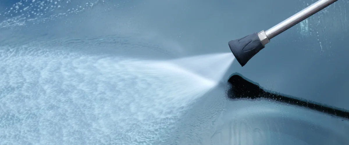 High-pressure water spray cleaning glass surface with power washing equipment High-pressure water spray cleaning glass surface with power washing equipment