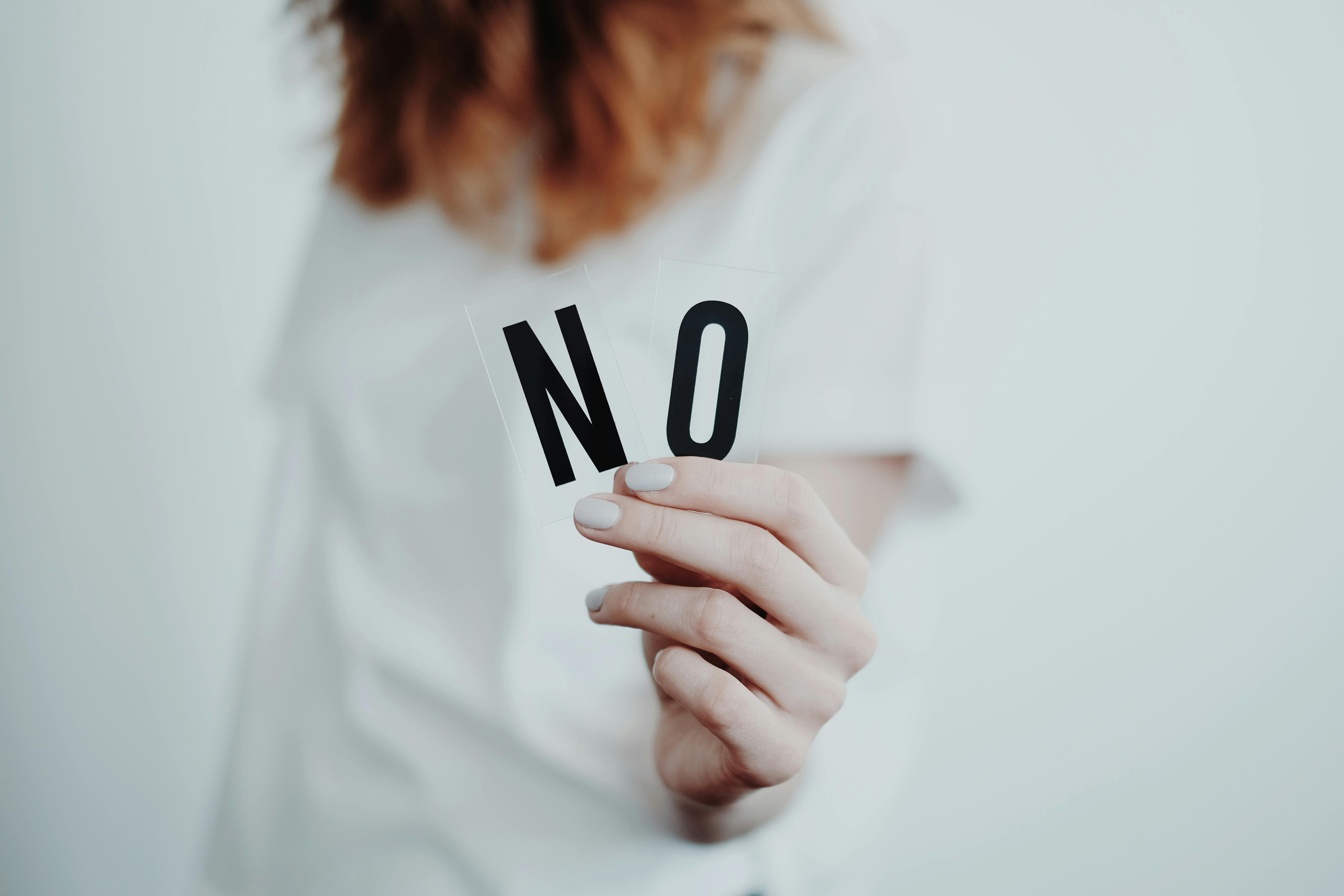 Girl holding the letters "NO"