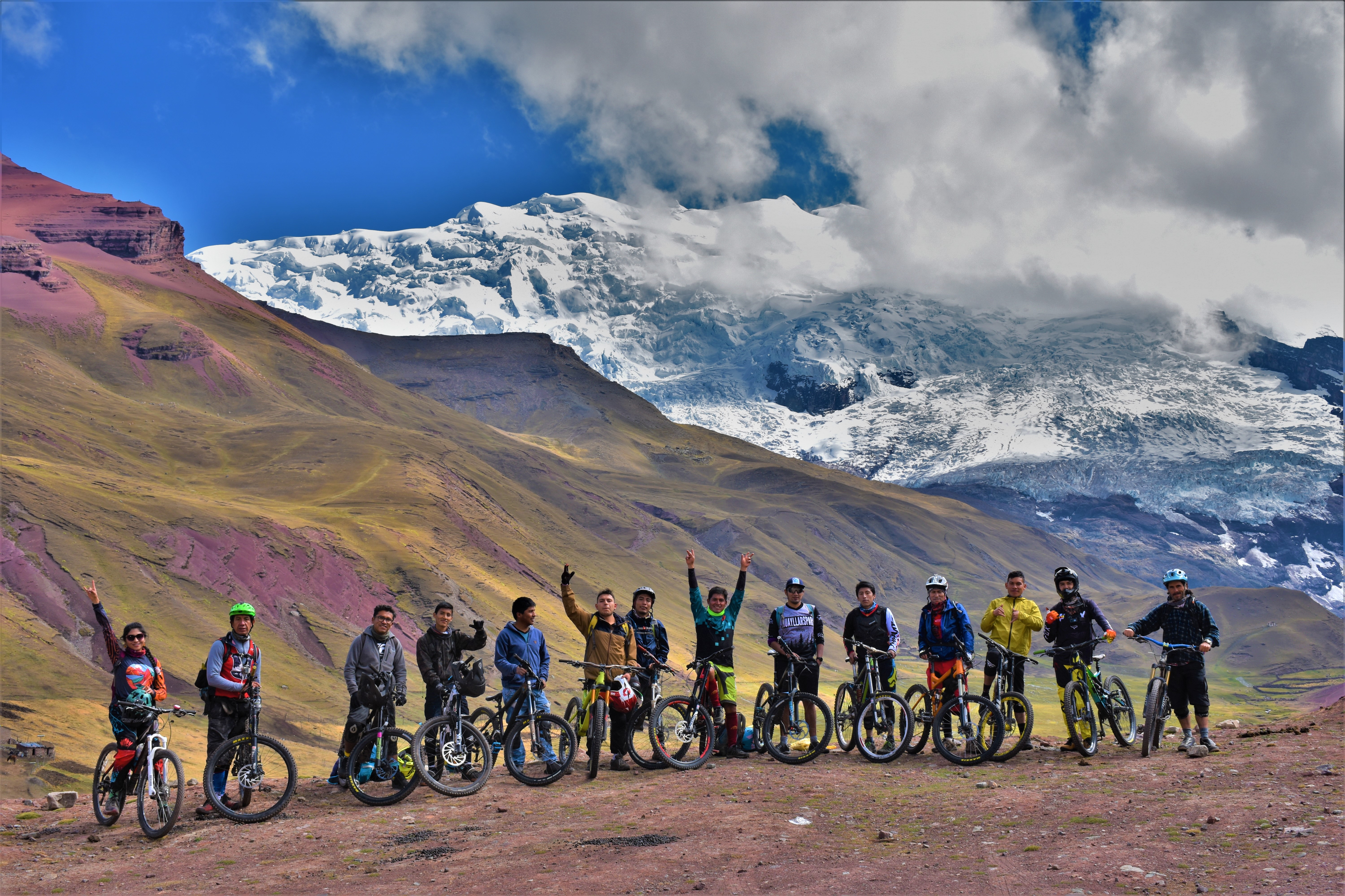 Large group mountain biking with glacier background