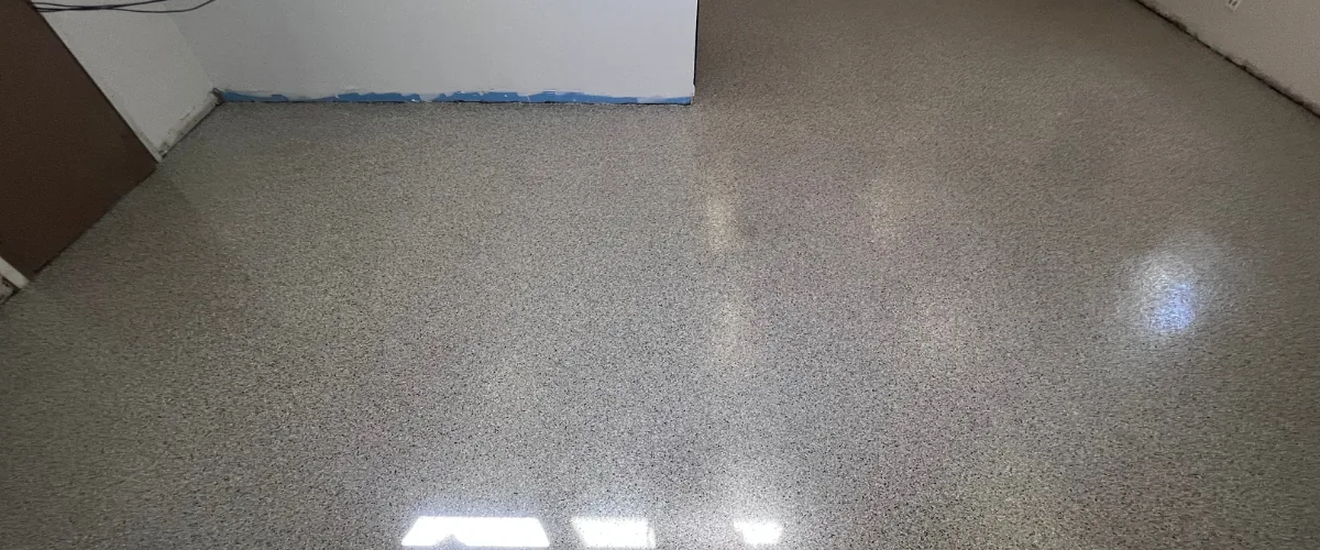 Epoxy garage floor coating with flake finish and clean edge detailing near the garage entrance.