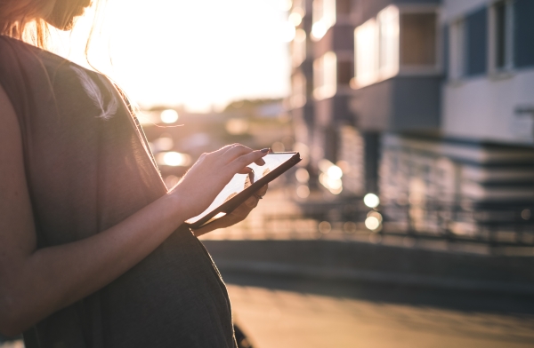 woman using a tablet at sunset