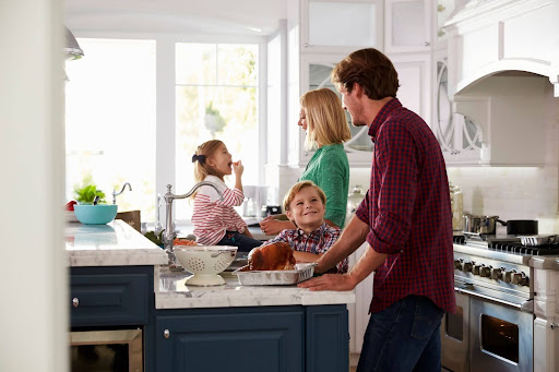 A family, 2 son and daughter and thier mom and dad. Son is smiling to his dad.