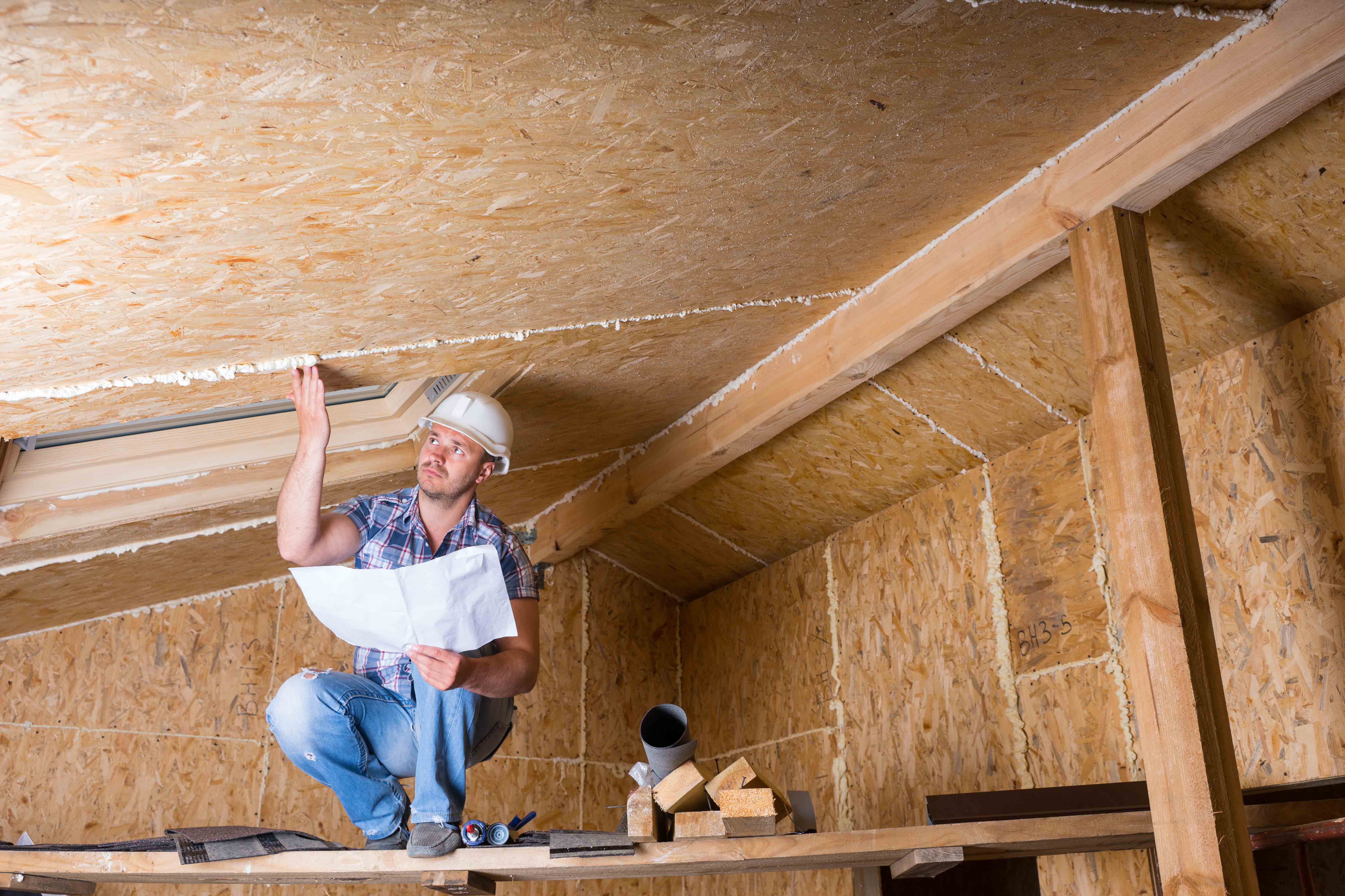  A man in a hard hat inspecting the ceiling.