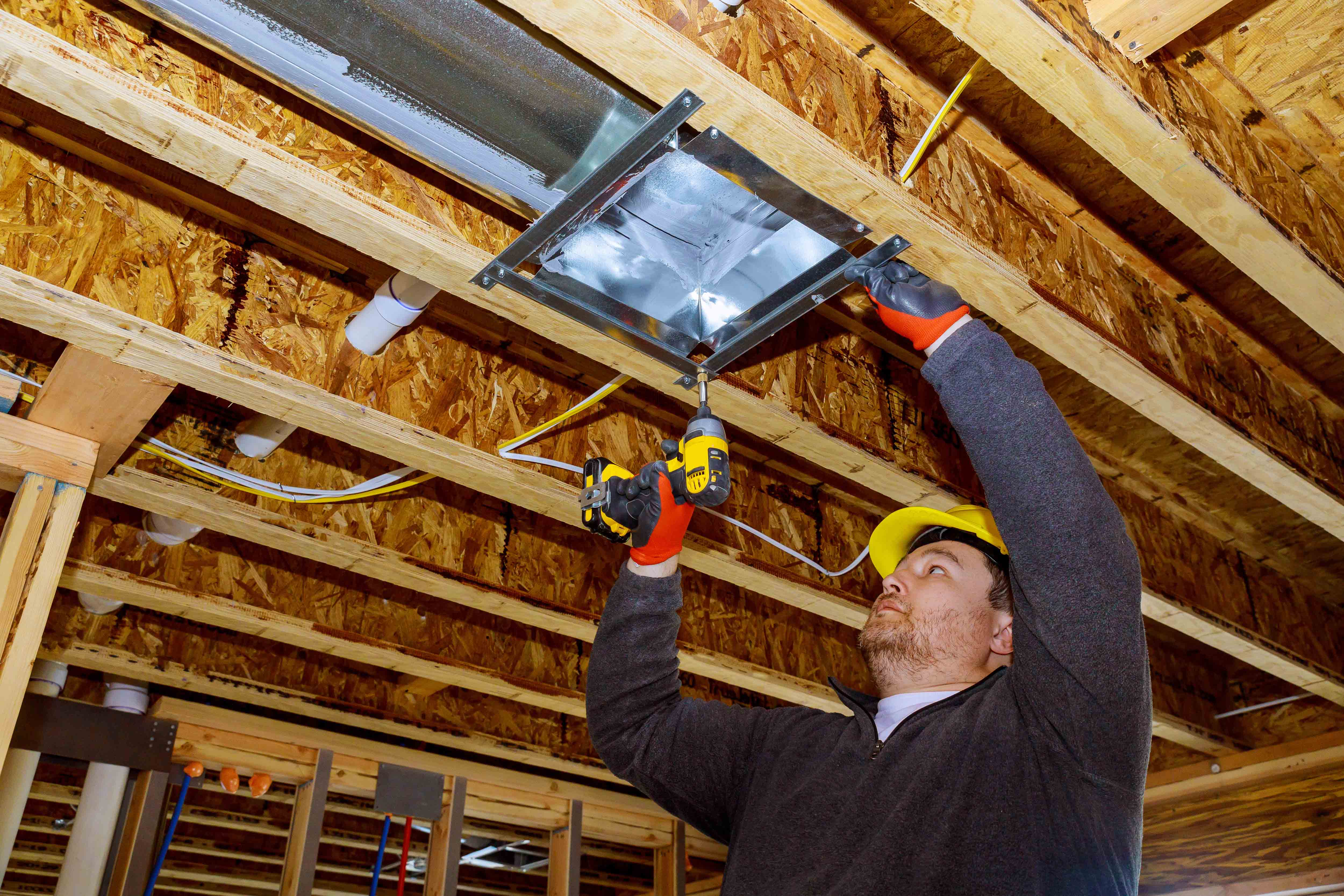 A worker fixing the ceiling in a home.