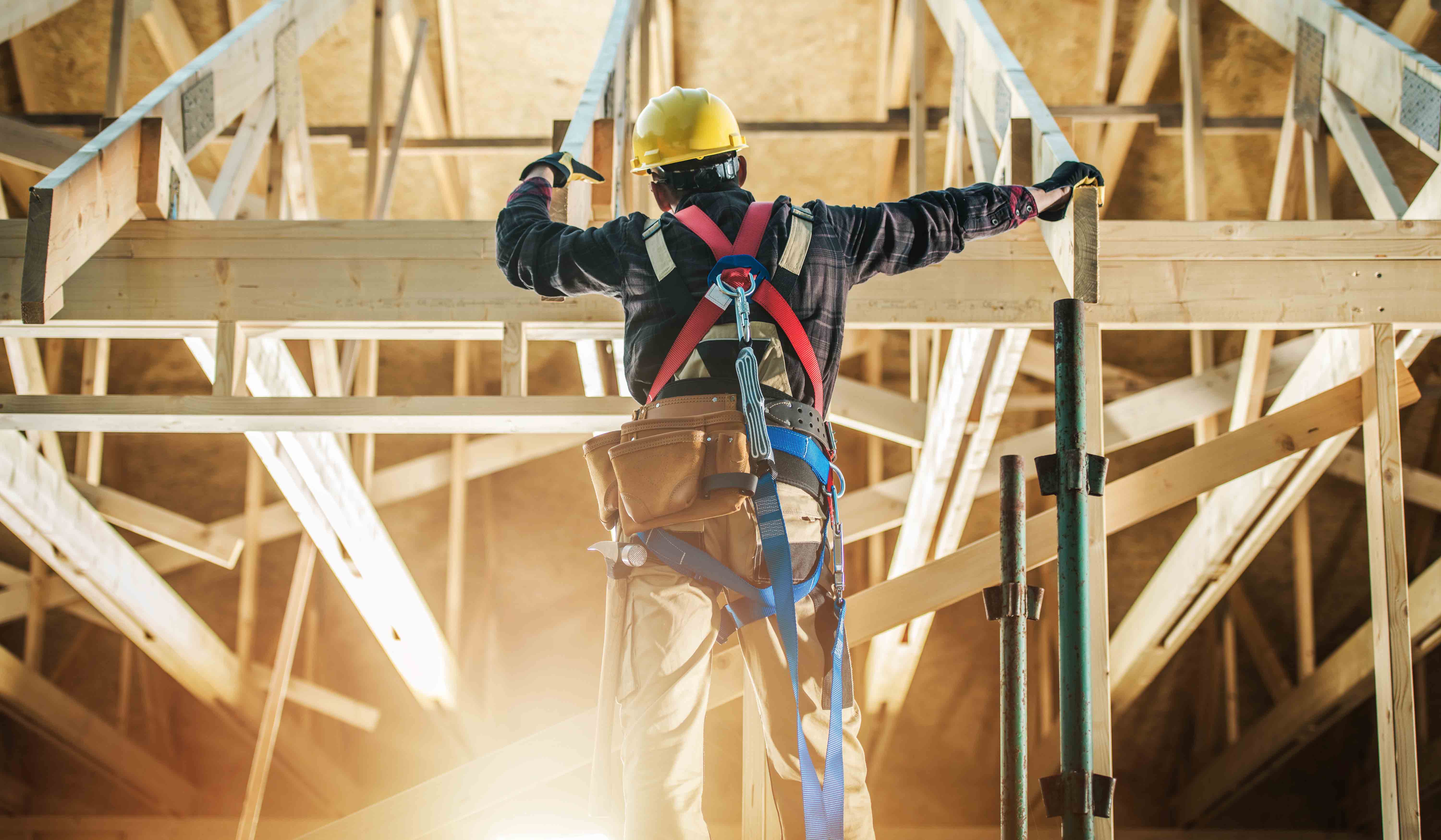 A man on a ladder fixing a roof.
