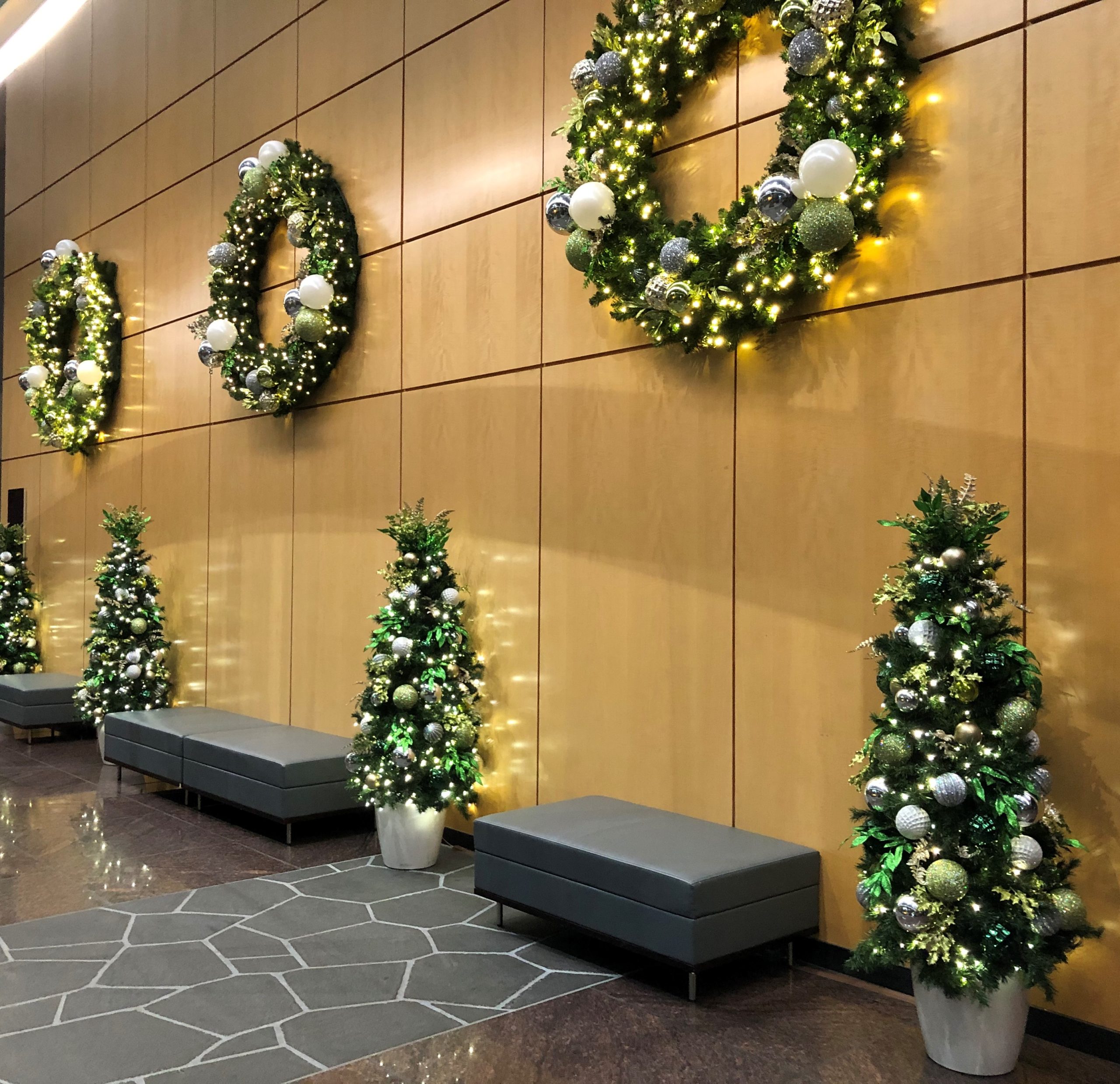 Holiday décor including lit tree and garland in business lobby
