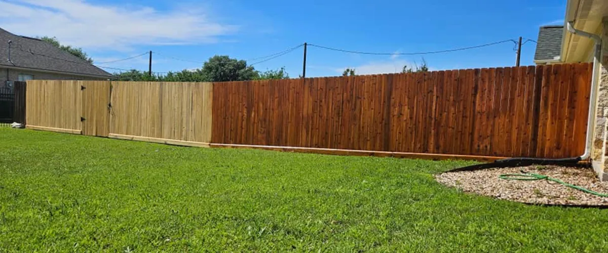 Backyard fence featuring two-tone wood panels with fresh stain in College Station. Backyard fence featuring two-tone wood panels with fresh stain in College Station.